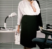 Naughty blond secretary in shirt, stockings and heels bends-over answering