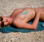 Beautiful ginger babe shows off slender physique and firm boobs at beach