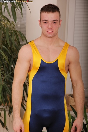 Gorgeous dude displays his hot body with hard muscles in blue and yellow spandex before he peels down his white supporter and jacks his cock wearing his blue and yellow rubber shoes. - Picture 1