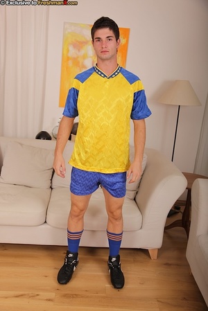 Gorgeous soccer player in blue and gold uniform takes off his shirt and shows his muscular body before he pulls down his shorts and black brief and reveals his large dick as he sits on a white couch. - XXXonXXX - Pic 2