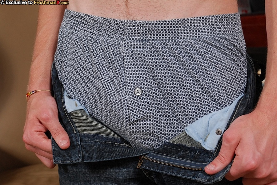 Stunning stud peels off his red shirt and bares his skinny body before he strips down his jeans and gray boxers and expose his giant meat stick as he sits naked on a brown couch. - XXXonXXX - Pic 6