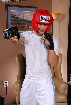 Boxing champ takes off his white shirt and shorts then displays his hunk body wearing his red head gear, blue cycling shorts and black gloves before he gets naked and bares his hard cock in different poses on a brown couch. - XXXonXXX - Pic 2