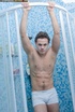 Muscular dude gets in a shower wearing his white cycling shorts and teases