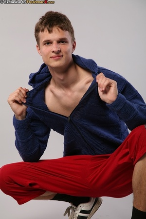 Handsome hottie peels off his blue jacket and red jogging pants then peels down his black brief and displays his big dick in different poses in a white studio. - XXXonXXX - Pic 2