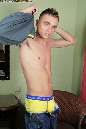 Sweet dude with spikey hair wearing gray shirt and jeans takes them off and shows his skinny body before he peels down his yellow and blue brief and reveals his big cock on a white bed. - XXXonXXX - Pic 4