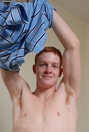 Redhead hottie shows his thin muscular body as he strips off his blue and black shirt and gray shorts before he peels down his black boxers and strokes his large dick on a wooden stool. - Picture 3