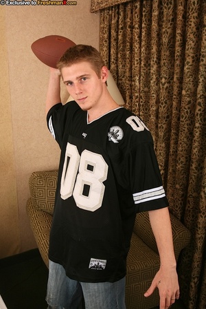 Teen stud strips off his black shirt and bares his muscular body while holding a football before he pulls down his jeans and black brief and reveals his small dick as he sits naked on a brown couch. - XXXonXXX - Pic 1