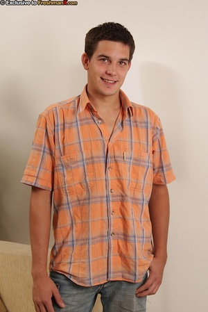 Handsome stud slowly peels off his orange and blue checkered polo, jeans and white brief then expose his hot body and huge dick while he jerks off on a brown couch. - Picture 1