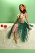 Seductress in green hula skirt and tight revealing flower bikini top slowly