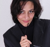 Brunette MILF secretary strips and finger-fucks herself on the table.