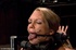 Blonde’s arms are bound behind her back as she is fastened to a Sybian