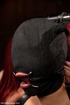 Perky girl’s read hair sticks out of a black mask that covers her face