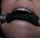 Purple and red wax cover a wench who is bound to a chair and flogged with