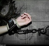 A small whiffle ball is used to gag a darling dark-haired submissive with