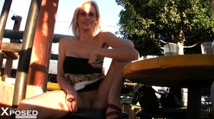 Blonde chick with glasses wearing vari colored tube dress sits on a brown chair, spreads wide and bares her lusty pussy in public before she pops her huge tits out. - XXXonXXX - Pic 3