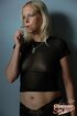 A milf in a see through top smokes her cigarette while removing her top