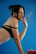 Fit black-haired babe in black bra, skirt and panties smokes cigarette