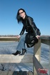 Hot brunette in a leather jacket puts on her sunglasses and smokes