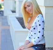 She keeps white polka dot top on but lowers her jean shorts and opens