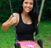 Luscious babe sits on a swing and displays her indulging body before she