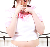 Babe in cute girly clothes licks candy while servicing pussy.