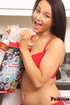 Teen strips as she makes a bowl of cereal in the kitchen.