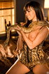 Brunette snake charmer in gold corset seduces with snake on sexy tits