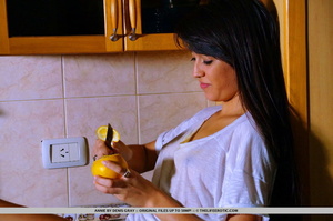 Cute chick cuts a lemon and squeezes the - Picture 1