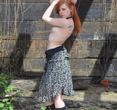 Kinky redhead strips and plays with her cunt outdoors.
