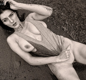 Seductive brunette in panties and dark top showing hot tits and ass on