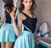 Brunette girl adores her sexy naked figure in front of a mirror.