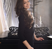 Sexy brunette strips her black lingerie on piano after playing some tunes.