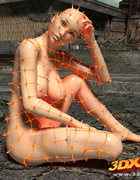 Babe with big boobs in orange fishnet poses seductively on charred earth.