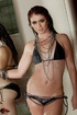 Smoky hot brunette in silver chains and black bikini shows nude body by