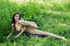 Teen round boobed chick poses on the glade on green grass