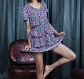 Sweetie poses hot in blue cute summer dress on leather couch