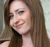 Beautiful brunette takes off white silk peignoir on the bed