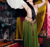 Well-formed brunette in a fortuneteller's revealing outfit showing off