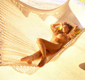 Showy brunette wearing a colorful flowery robe on a swing looks great