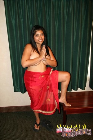 Smily indian harlot in red national outfit touching her big tits while posing on a cam and flashing her black panty - Picture 4