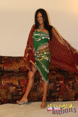 Grey eyed indian girl in green outfit undressing and exposing her black thongs and big juggs on the sofa - Picture 1