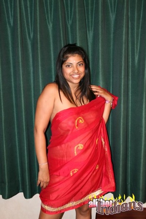 Red saree dressed indian gal with big titties stripteasing and exposing her goods on the table - Picture 2