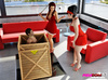 Two Dommes in red get naked, let their sub out of a box and sit on his