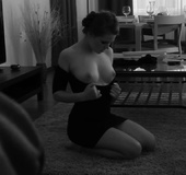 Brunette in black dress plays with her big tits on the floor