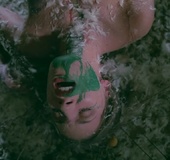 Fairytale brunette gets naked on a bed of white feathers before playing