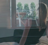 Long legged blonde poses in sexy dress and dark nylon stockings