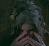 Quirky girl has fun covering herself in paint and playing with white feathers