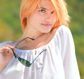 Exquisite orange blonde in white loose top and denim shorts showing off
