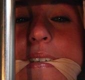 Pretty busty blonde in checkered white outfit caged, gagged and bound