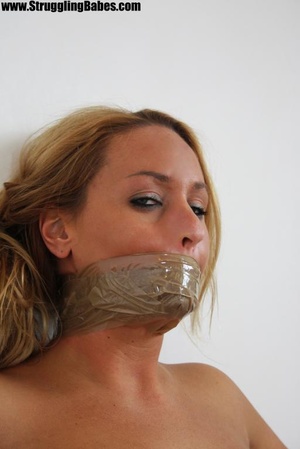 Busty blonde in black skirt with hands tied, mouth gagged and tits squeezed - Picture 9